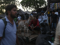 A boy is sitting with his goat on a cycle cart in a livestock market ahead of the Muslim festival of Eid al-Adha in the old quarters of New...