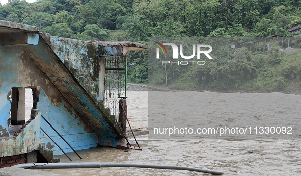 Villagers are walking on the roads adjacent to the Teesta River, where water is entering the roads near their houses due to heavy rain in th...