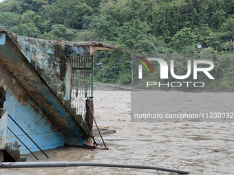 Villagers are walking on the roads adjacent to the Teesta River, where water is entering the roads near their houses due to heavy rain in th...