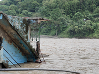 Villagers are walking on the roads adjacent to the Teesta River, where water is entering the roads near their houses due to heavy rain in th...