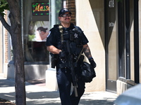 A police officer with tactical gear is executing a search warrant at Oakton Spa. Homeland Security Investigations Agents and Skokie Police a...