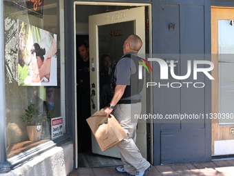 Police and federal agents are taking out evidence bags with evidence collected as a result of the search warrant at Oakton Spa. Police are p...