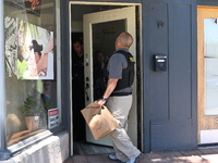 Police and federal agents are taking out evidence bags with evidence collected as a result of the search warrant at Oakton Spa. Police are p...