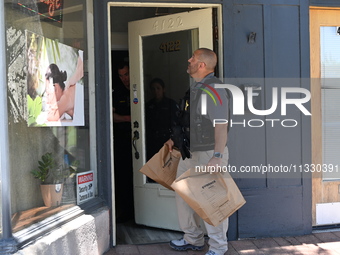 Police and federal agents are taking out evidence bags with evidence collected as a result of the search warrant at Oakton Spa. Police are p...