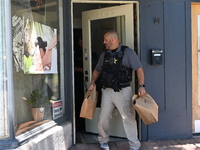 Police and federal agents are taking out evidence bags with evidence collected as a result of the search warrant at Oakton Spa. Police are p...