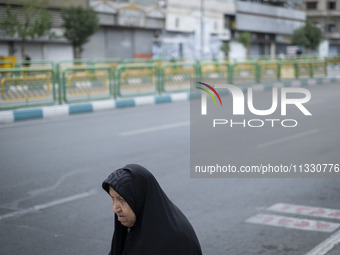 A veiled Iranian worshipper is walking along Enghelab (Revolution) Avenue, as she is making her way to the University of Tehran for Friday p...