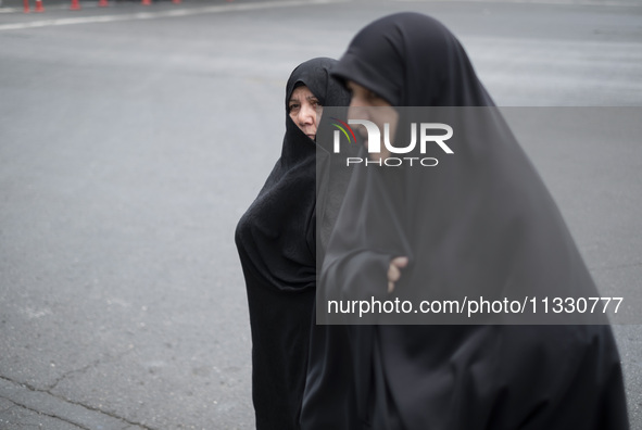 Two veiled Iranian worshippers are walking along Enghelab (Revolution) Avenue, as they are making their way to the University of Tehran for...