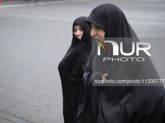 Two veiled Iranian worshippers are walking along Enghelab (Revolution) Avenue, as they are making their way to the University of Tehran for...