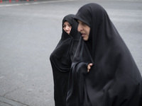 Two veiled Iranian worshippers are walking along Enghelab (Revolution) Avenue, as they are making their way to the University of Tehran for...