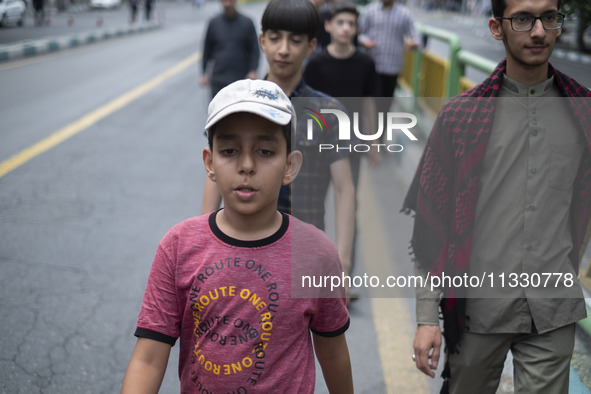 Young Iranian men are walking along Enghelab (Revolution) Avenue, as they are making their way to the University of Tehran for Friday prayer...