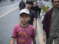 Young Iranian men are walking along Enghelab (Revolution) Avenue, as they are making their way to the University of Tehran for Friday prayer...