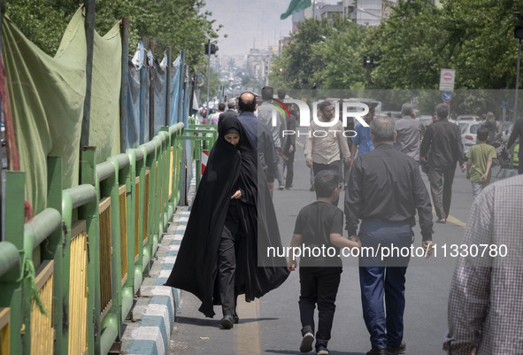 A veiled Iranian worshipper is walking along Enghelab (Revolution) Avenue, as she is making her way to the University of Tehran for Friday p...