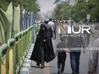 A veiled Iranian worshipper is walking along Enghelab (Revolution) Avenue, as she is making her way to the University of Tehran for Friday p...