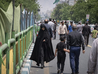 A veiled Iranian worshipper is walking along Enghelab (Revolution) Avenue, as she is making her way to the University of Tehran for Friday p...