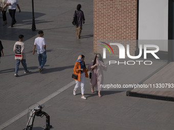 Iranian youths are walking along a recreation area in western Tehran, Iran, on June 14, 2024, amidst the early presidential election campaig...