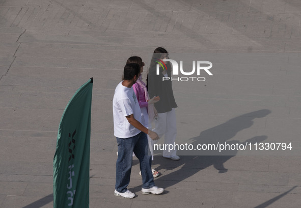 Iranian youths are walking along a recreation area in western Tehran, Iran, on June 14, 2024, amidst the early presidential election campaig...