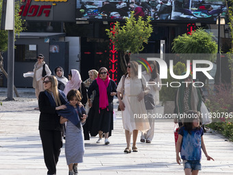 An Iranian family is walking along a recreation area in western Tehran, Iran, on June 14, 2024, amidst the early presidential election campa...