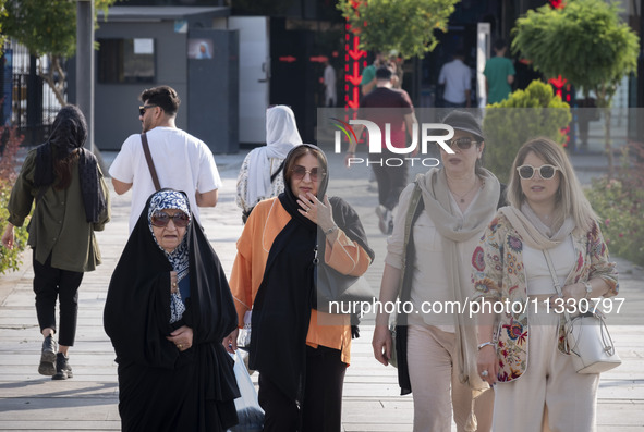 An Iranian family is walking along a recreation area in western Tehran, Iran, on June 14, 2024, amidst the early presidential election campa...