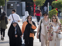 An Iranian family is walking along a recreation area in western Tehran, Iran, on June 14, 2024, amidst the early presidential election campa...