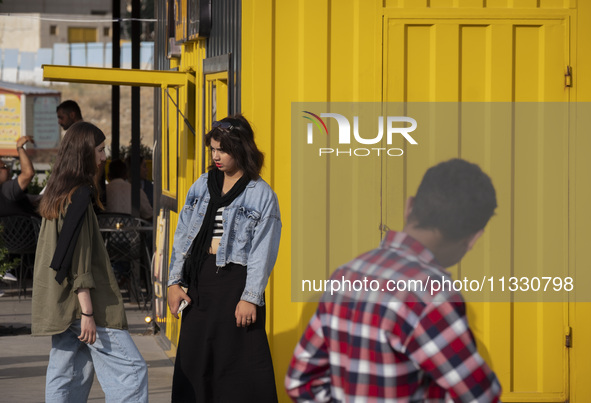 Two young Iranian women are standing together in a recreation area in western Tehran, Iran, on June 14, 2024, amidst the early presidential...