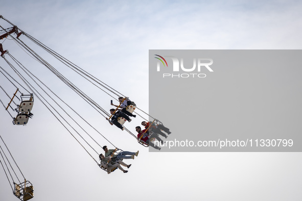 Iranian youths are riding on a star flyer in a recreation area in western Tehran, Iran, on June 14, 2024, amidst the early presidential elec...