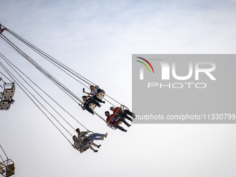 Iranian youths are riding on a star flyer in a recreation area in western Tehran, Iran, on June 14, 2024, amidst the early presidential elec...