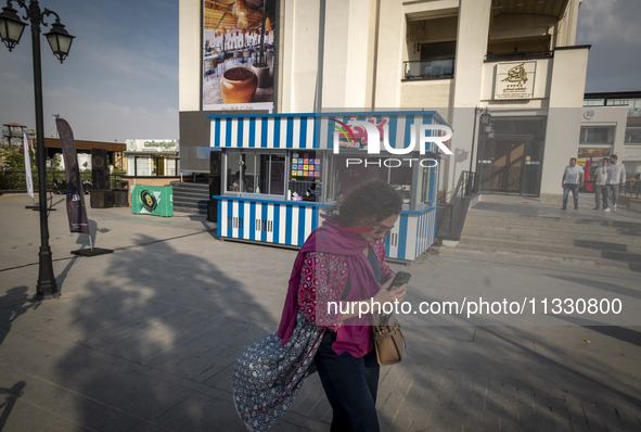 A young Iranian woman is walking along a recreation area in western Tehran, Iran, on June 14, 2024, amidst the early presidential election c...