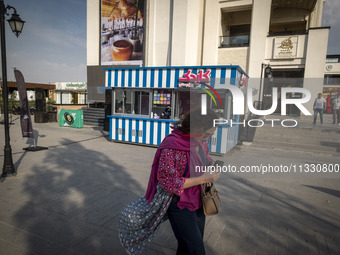 A young Iranian woman is walking along a recreation area in western Tehran, Iran, on June 14, 2024, amidst the early presidential election c...