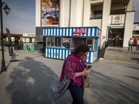 A young Iranian woman is walking along a recreation area in western Tehran, Iran, on June 14, 2024, amidst the early presidential election c...