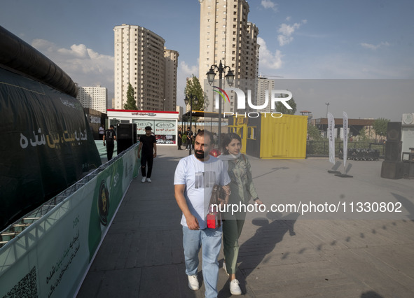 Iranian youths are walking along a recreation area in western Tehran, Iran, on June 14, 2024, amidst the early presidential election campaig...