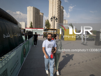 Iranian youths are walking along a recreation area in western Tehran, Iran, on June 14, 2024, amidst the early presidential election campaig...