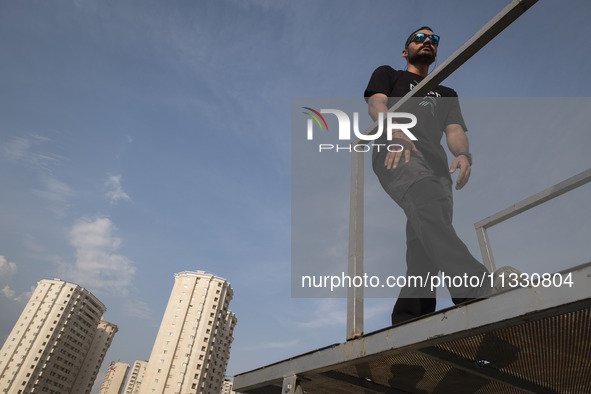 A young Iranian diver is preparing to jump during a street diving event organized and held by Tehran's Adrenaline Park, in a recreation area...