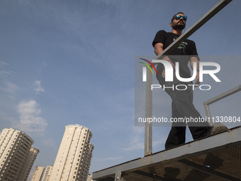 A young Iranian diver is preparing to jump during a street diving event organized and held by Tehran's Adrenaline Park, in a recreation area...