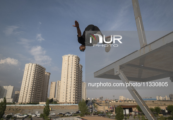 A young Iranian diver is jumping during a street diving event organized and held by Tehran's Adrenaline Park, in a recreation area in wester...