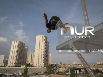 A young Iranian diver is jumping during a street diving event organized and held by Tehran's Adrenaline Park, in a recreation area in wester...