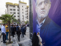 Two young women are walking past a banner featuring a portrait of Masoud Pezeshkian, a reformist presidential candidate, during an electoral...