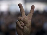 A supporter of Masoud Pezeshkian, Iranian reformist presidential elections candidate, is flashing a Victory sign while taking part in an ele...