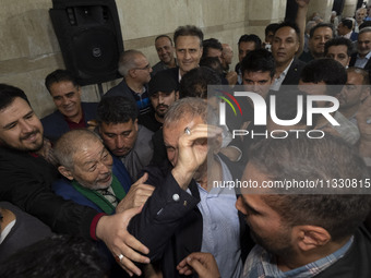 Supporters of Masoud Pezeshkian, a reformist presidential candidate, are greeting him while he is arriving at an electoral campaign rally in...