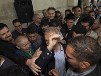 Supporters of Masoud Pezeshkian, a reformist presidential candidate, are greeting him while he is arriving at an electoral campaign rally in...