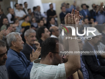 A supporter of Masoud Pezeshkian, Iranian reformist presidential elections candidate, is clapping while taking part in an electoral campaign...