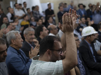 A supporter of Masoud Pezeshkian, Iranian reformist presidential elections candidate, is clapping while taking part in an electoral campaign...