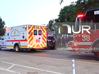 An ambulance and a fire engine are arriving first at the crime scene where a 13-year-old is being shot and critically wounded in Chicago, Il...