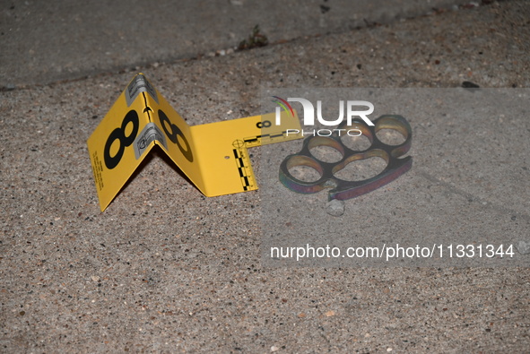 An evidence marker is highlighting evidence found at the crime scene. An unidentified male is being wounded after being shot while standing...