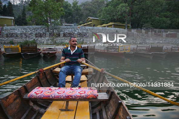 A boatman is rowing a boat along Sattal Lake in Sattal (Sat Tal), Uttarakhand, India, on April 20, 2024. 