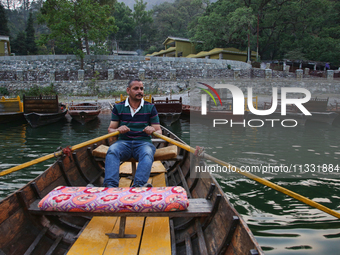 A boatman is rowing a boat along Sattal Lake in Sattal (Sat Tal), Uttarakhand, India, on April 20, 2024. (