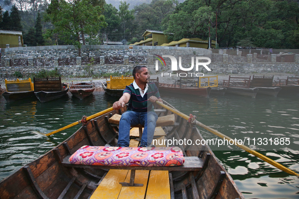 A boatman is rowing a boat along Sattal Lake in Sattal (Sat Tal), Uttarakhand, India, on April 20, 2024. 