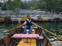 A boatman is rowing a boat along Sattal Lake in Sattal (Sat Tal), Uttarakhand, India, on April 20, 2024. (