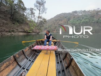 A boatman is rowing a boat along Sattal Lake in Sattal (Sat Tal), Uttarakhand, India, on April 20, 2024. (