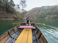 A boatman is rowing a boat along Sattal Lake in Sattal (Sat Tal), Uttarakhand, India, on April 20, 2024. (