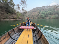 A boatman is rowing a boat along Sattal Lake in Sattal (Sat Tal), Uttarakhand, India, on April 20, 2024. (